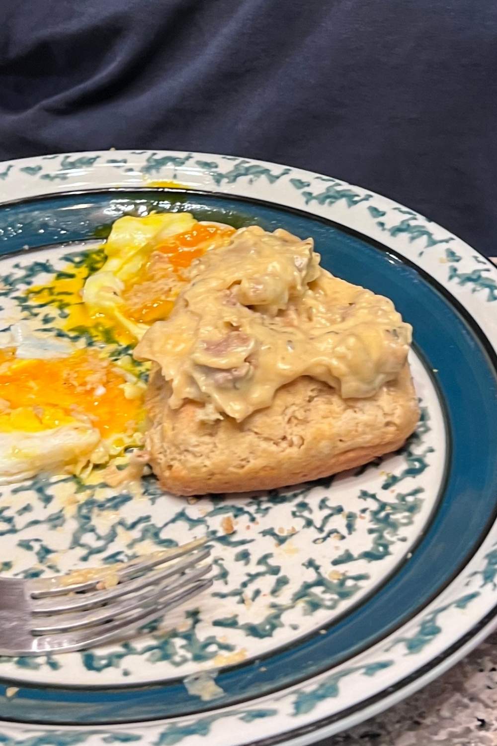 Sourdough discard biscuits and sausage gravy for two on a blue speckled plate at a Kentucky homestead